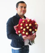 Hombre ramo de rosas rojas con ferreros