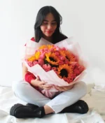 Mujer con ramo de flores de girasoles con rosas rosas