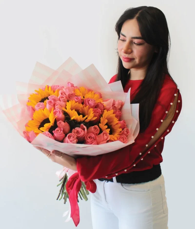 Mujer con ramo de flores de girasoles con rosas rosas