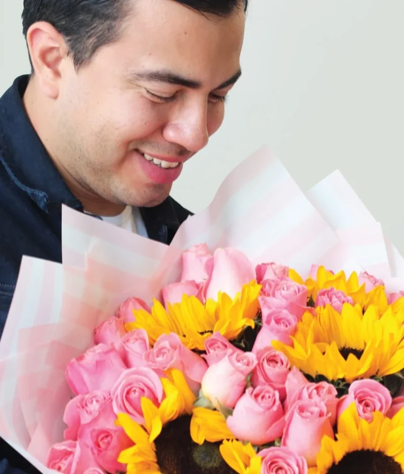 Hombre con ramo de flores de girasoles con rosas rosas