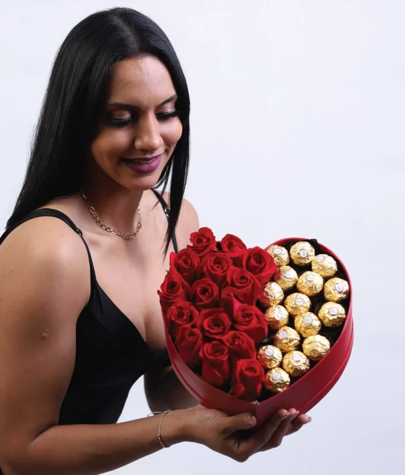 Mujer arreglo en forma de corazón con rosas rojas y ferreros