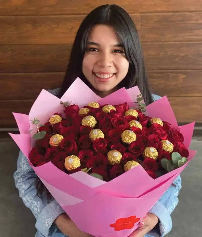 Mujer con ramo de rosas rojas y ferreros