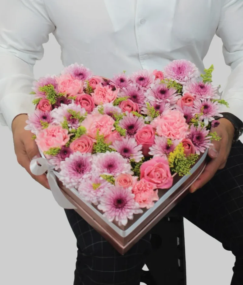 Hombre con regalo forma de corazón flores rosas