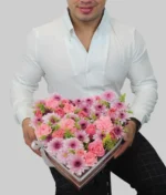 Hombre con regalo forma de corazón flores rosas