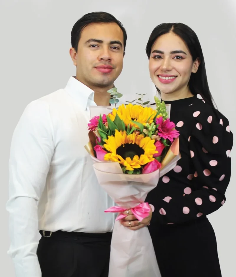 Pareja con ramo girasol con flores rosas