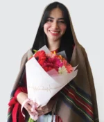 Mujer sonriendo con ramo de flores rosas y naranjas