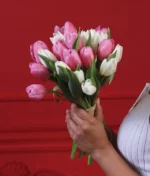 Mujer sosteniendo un ramo tulipanes rosas