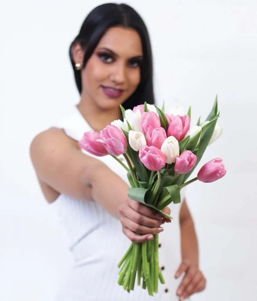 Mujer sosteniendo un ramo tulipanes rosas