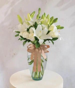 Ramo de flores blancas en un jarrón con fondo gris