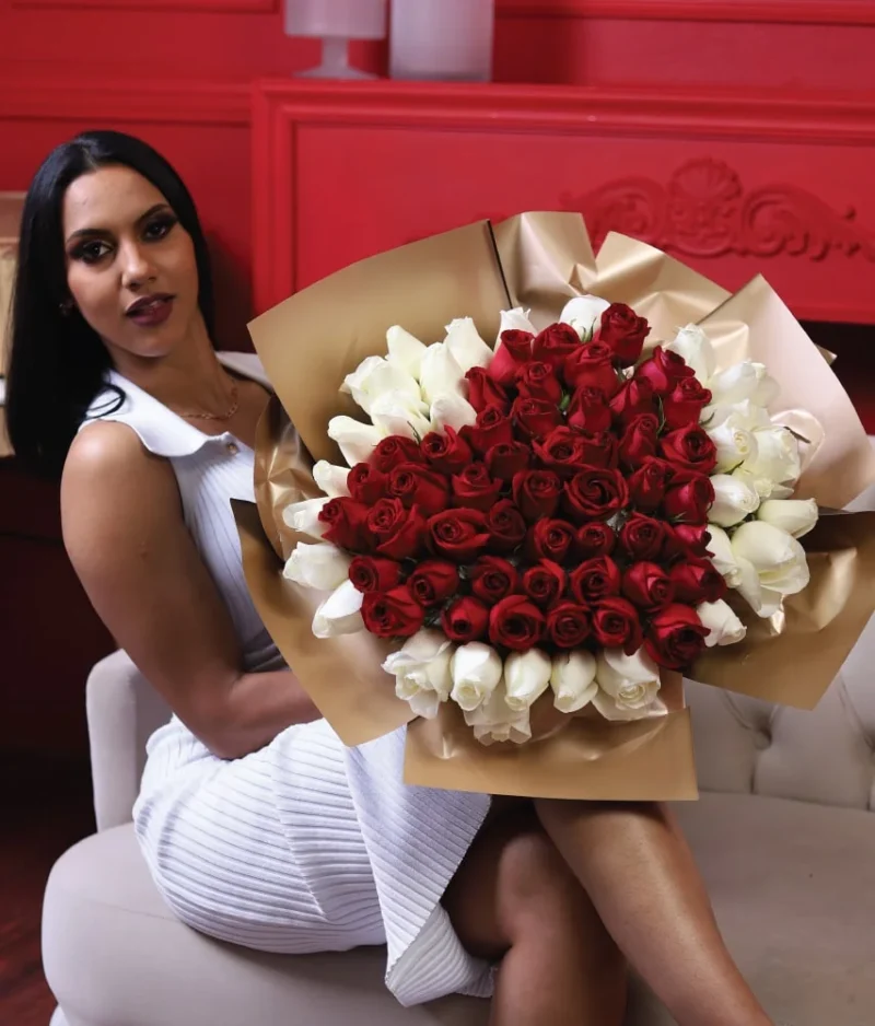 mujer sonriente sosteniendo un ramo de rosas rojas en forma de corazón con fondo rojo